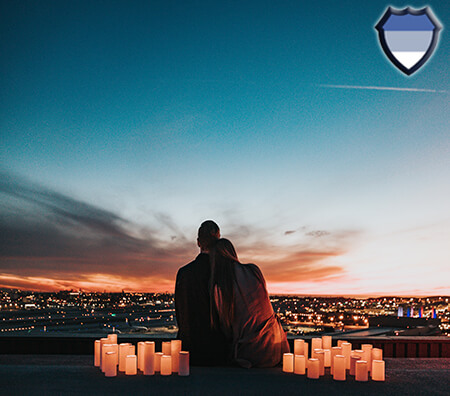 Couple sitting together at night overlooking a city skyline