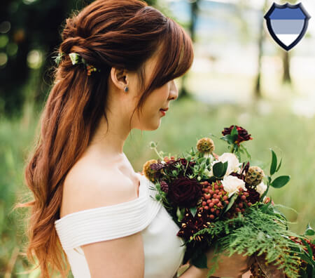 An Asian lady holding flowers while wearing a wedding dress
