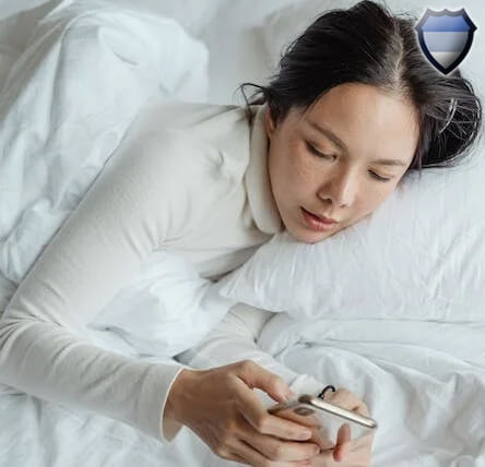Lady using a smartphone while laying in bed