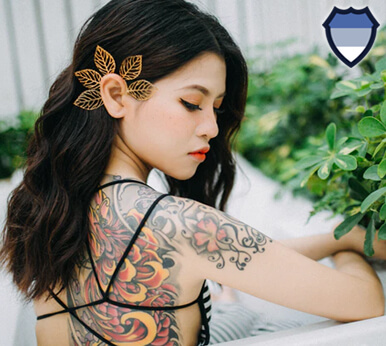 Thai woman with tattoos on her back and arm