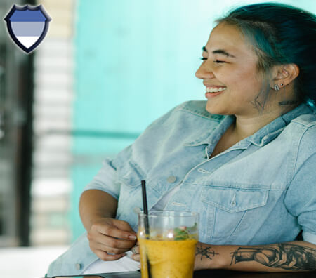 Asian lady smiling while sitting with a cold drink