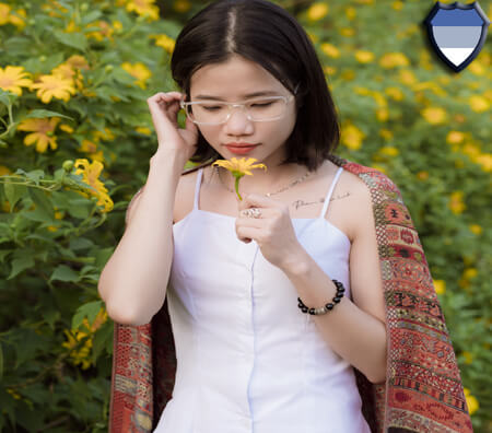 An Asian lady smells a flower