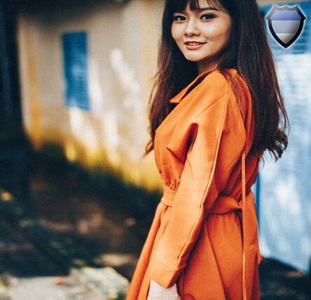 Asian lady smiling while wearing an orange jacket