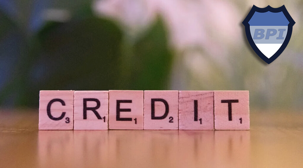 The word credit spelled out with wooden blocks on a table