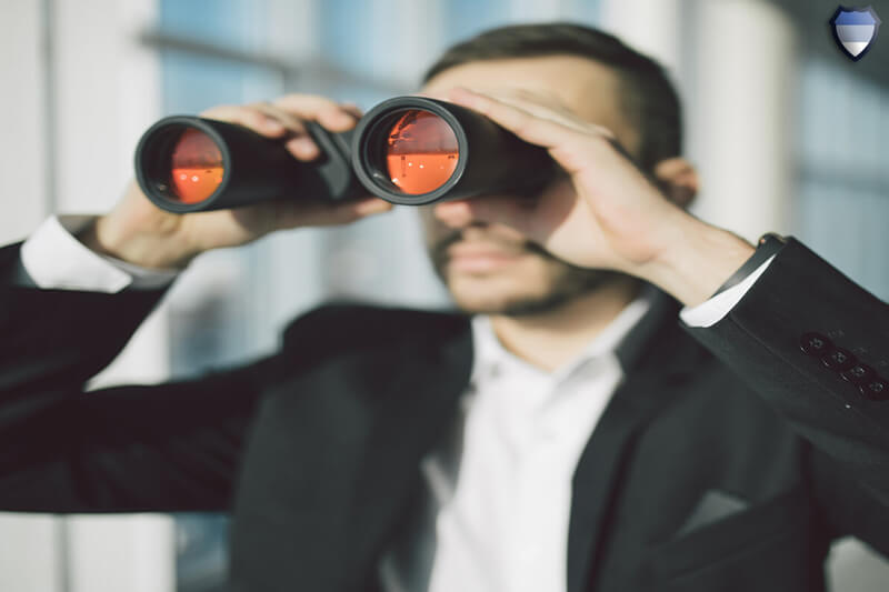 A businessman looking through binoculars