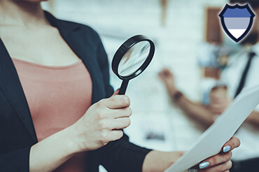 An investigator checking documents with a magnifying glass
