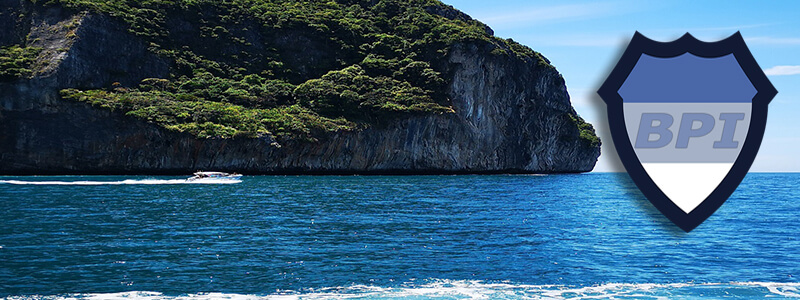 A motor boat driving past an island off of Phuket